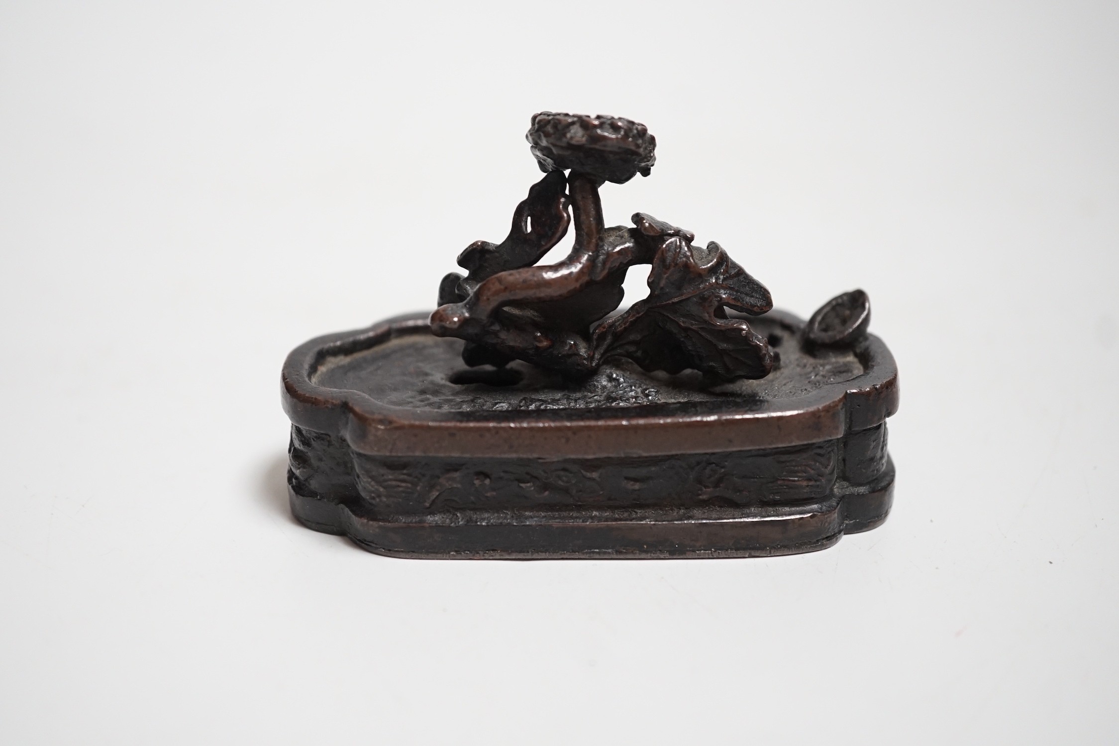 A Chinese bronze water-dropper of a flowering shrub in a jardiniere, 17th/18th century, 8cms wide